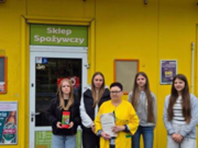 Zdjęcie przed sklepem z wolontariuszami z Liśnika Dużego pomagającymi i grającymi o Skarb Solidarności 