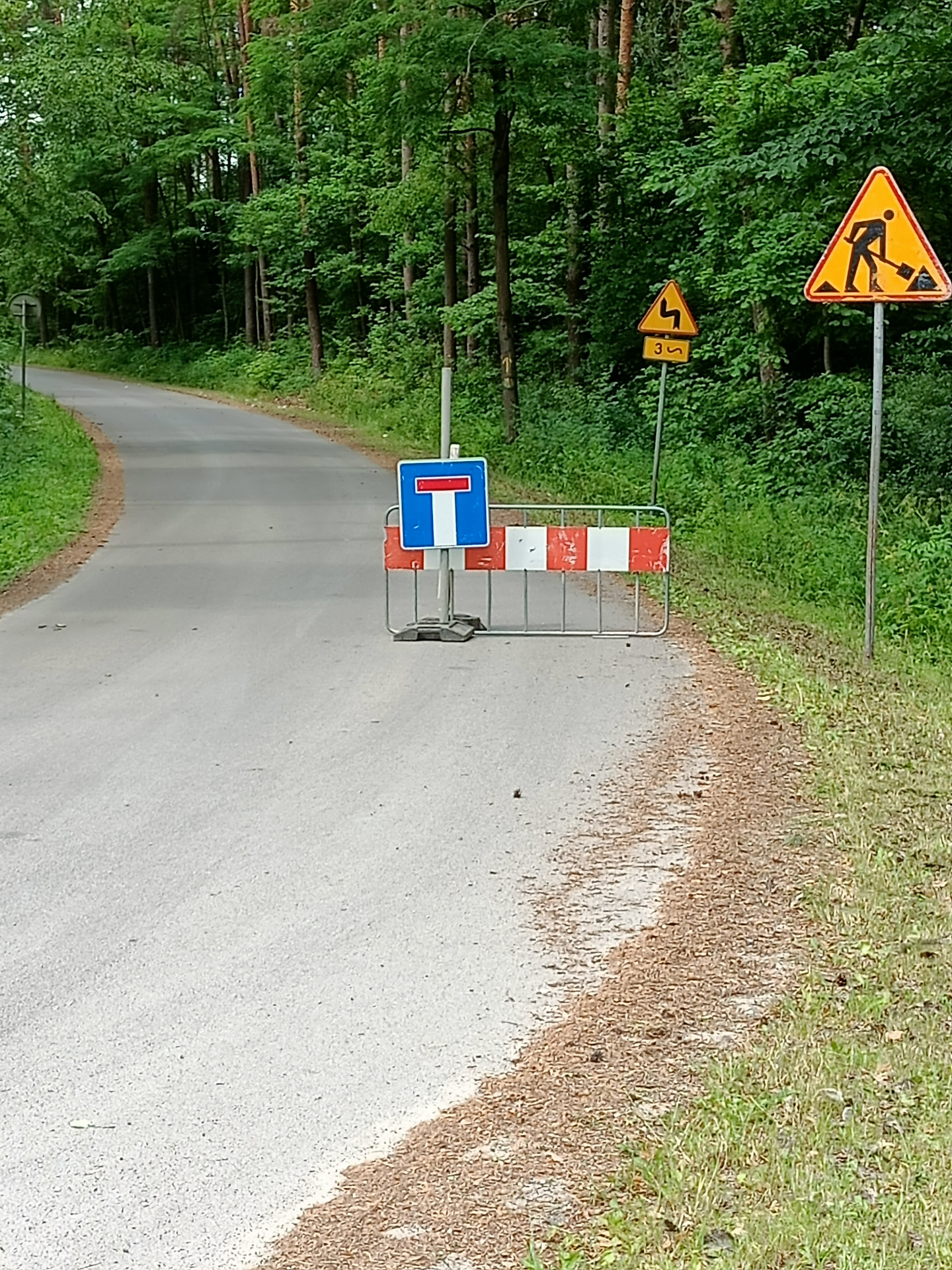 Zdjęcie przedstawiajace drogę oraz płotek 
