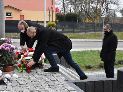 Sekretarz Gminy i Przewodniczący Rady Gminy stawiają zniczy przy pomniku