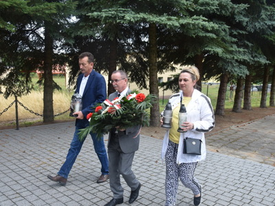 zdjęcie złożenie wiązanki i zniczy przed pomnikiem