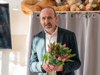 NA zdjęciu Zastępca Burmistrza Jacek Marcinkowiski trzymający bukiet tulipanów,