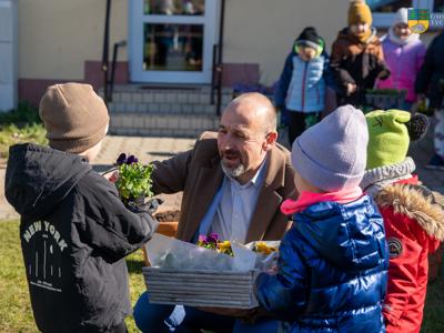 Na zdjęciu Zastępca Burmistrza Tychowa Jacek Marcinkowski przekazuje kwiatki dzieciom z przedszkola.