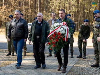 Na zdjęciu Paweł Urbaniak, Weteran Lester Schrenk oraz Robert Falana Burmistrz Tychowa składają kwiaty pod pomnikiem Obozu Stalag Luft IV.