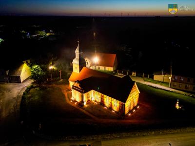 Iluminacja Kościoła M. B. Wspomożenia Wiernych w Tychowie na zdjęciu oświetlony kościół po zmroku.
