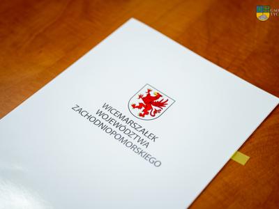 Na zdjęciu biała teczka z Herb województwa zachodniopomorskiego.