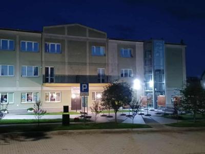 Na zdjęciu budynek ośrodka kultury wieczorem jest ciemno i świeca lampy solarne.