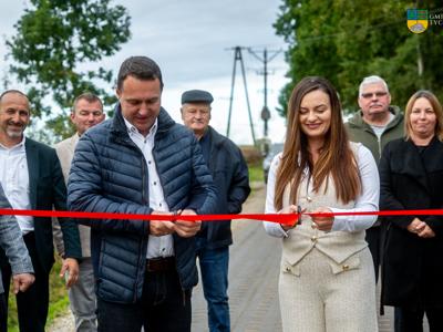 Uroczyste przecięcie wstęgi nowo wybudowanej drogi w miejscowości Kolonia Dobrowo. Wstęge przecina Burmistrz Tychowa oraz Przewodnicząca Rady Miejskiej w Tychowie.