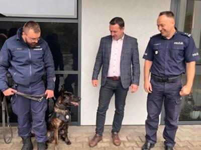 Na zdjęciu Burmistrz Tychowa Robert Falana, Komendat KPP w Biaogtadzie mł.insp. Krzysztof Rosiak oraz  st. post. Jakub Czeszun  z owczarkiem holenderskmi - Bruno – nowym psem w białogardzkiej Policji. 