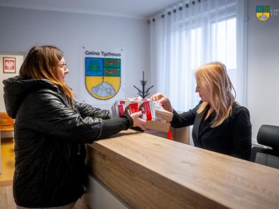 Kierownik Gminnego Ośrodka Pomocy Społecznej w Tychowie wręcza butony Sekreatarce Urzędu Miejskiego w Tychowie.