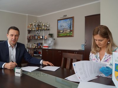 Na zdjęciu burmistrz Robert Falana i dyrektor Katarzyna Kalbarczyk podpisują umowę dotyczącą przekazanie zakupionego sprzętu komputerowego