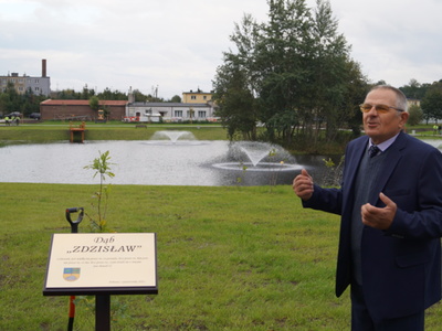 Zdzisław Polek stoi przy pamiątkowej tablicy 