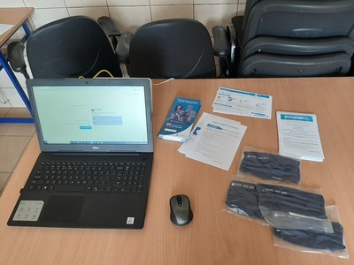 Na zdjęciu laptop udostępniony oraz ulotki i maski dla mieszkańców Kowalek Podczas Mobilnego Punktu Spisowego i Mobilnego Punktu Szczepień.