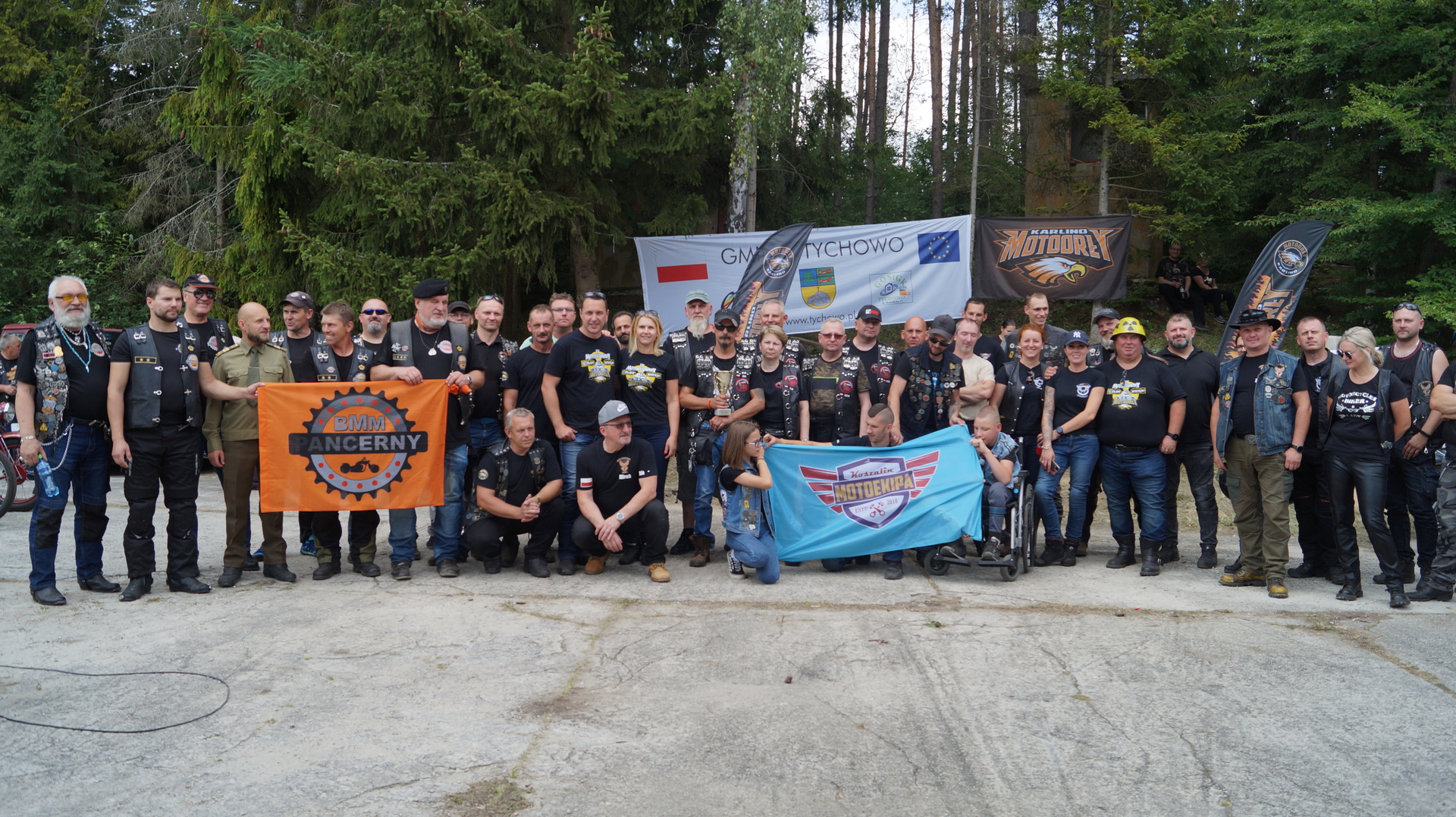 Zdjęcie grupowe przedstawiające uczestników IV Motoatomowego Zlotu Motocyklowego na placu przy bunkrach atomowych w Podborsku.