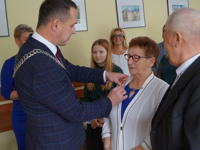 Burmistrz Robert Falana wręcza Pani Mariannie Medal za Długoletnie Pożycie Małżeńskie.