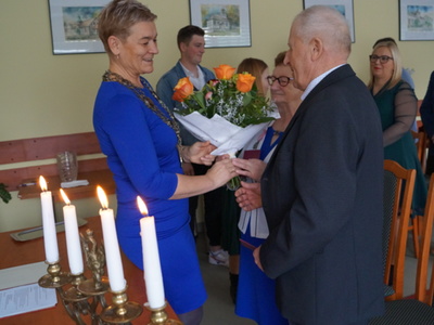 Kierownik USC Mariola Liksza wręcza kwiaty Państwu Jedlińskim.