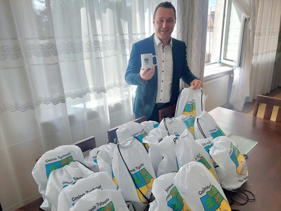 Na zdjęciu Burmistrz Robert Falana z pakietami promocyjnymi
