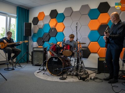 Na zdjęciu młodzież i instruktor grają na sprzęcie muzycznym podczas otwarcia pracowni muzycznej z funkcją studio nagrań.