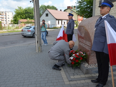 Starosta ostrowski Zbigniew Chrupek składa kwiaty przed obeliskiem 