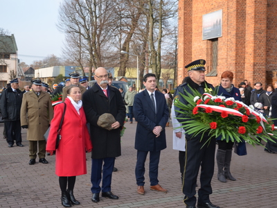 Przedstawiciele lokalnych władz samorządowych składają wieniec przed obeliskiem na Placu Wolności