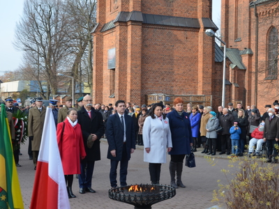 Przedstawiciele lokalnych władz samorządowych składają wieniec przed obeliskiem na Placu Wolności