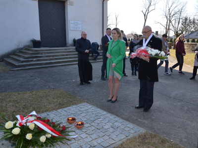 Starosta Ostrowski wraz z Radną Rady Powiatu w Ostrowi Mazowieckiej składają kwiaty pod pomnikiem w Nurze 