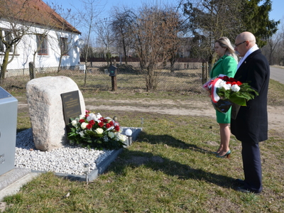 Starosta Ostrowski wraz Radną Rady Powiatu w Ostrowi Mazowieckiej składają kwiaty pod pomnikiem w Skłodach Piotrowicach 