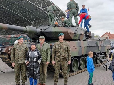 na fotografii Starosta Ostrowski z małżonką wraz z żołnierzami, na tle czołgu