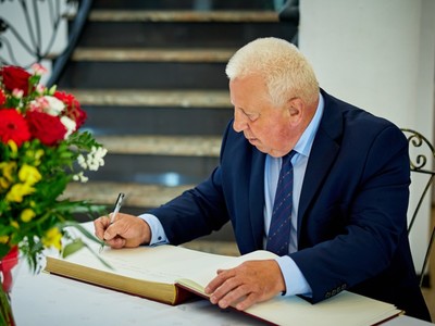 Członek Zarządu Powiatu w Ostrowi Mazowieckiej Stefan Rostkowski wpisuje się do pamiątkowej księgi 