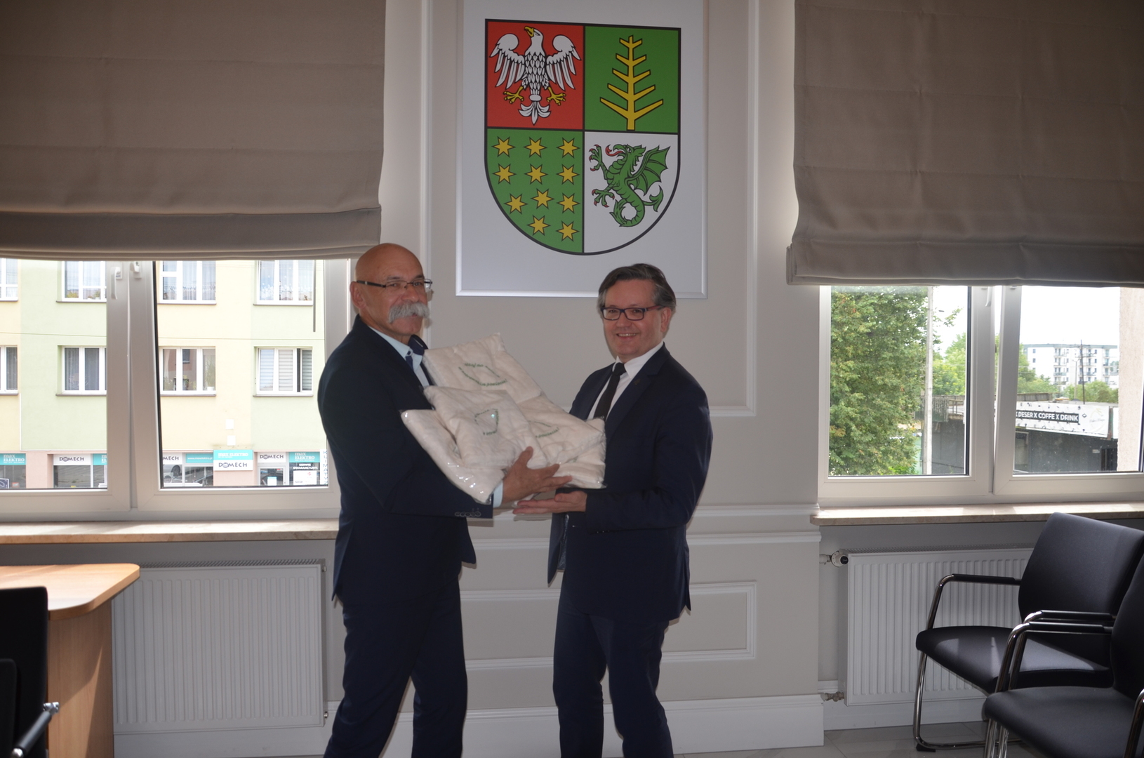 Starosta Ostrowski przekazuje kocyki Dyrektorowi Szpitala