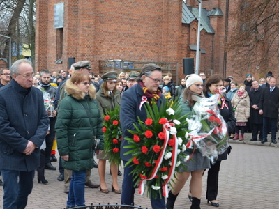 Składanie kwiatów przed pamiątkowym obeliskiem 
