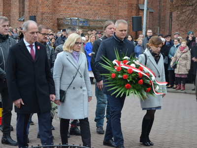 Składanie kwiatów przed pamiątkowym obeliskiem 