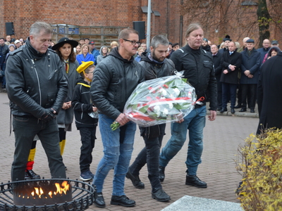 Składanie kwiatów przed pamiątkowym obeliskiem 
